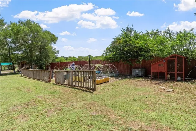 a view of a house with a backyard and a tree