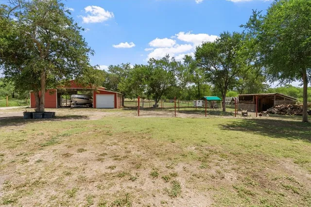 a view of a house with backyard and trees