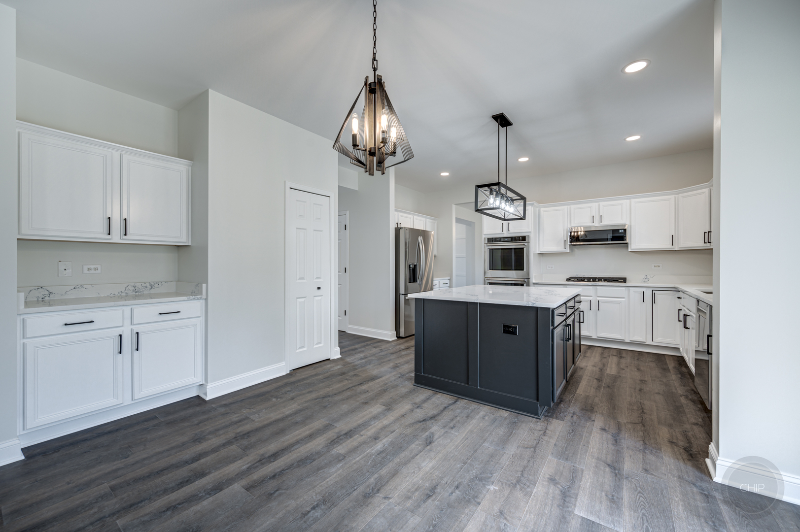 12948 Parterre Place Plainfield, IL 60585 - Photo 16 of 35 a large kitchen with stainless steel appliances granite countertop a sink dishwasher a stove and a dining table with wooden floor