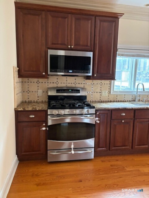 88 Maple Tree Avenue, Unit E Stamford, CT 06906 - Photo 11 of 50 a kitchen with granite countertop a stove and a microwave