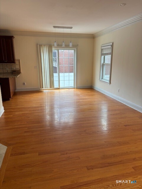 88 Maple Tree Avenue, Unit E Stamford, CT 06906 - Photo 17 of 50 a view of an empty room with window and wooden floor