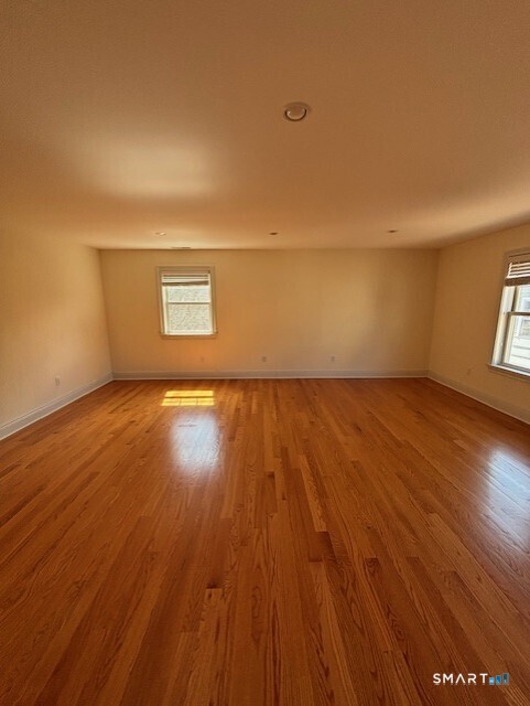 88 Maple Tree Avenue, Unit E Stamford, CT 06906 - Photo 21 of 50 an empty room with wooden floor and windows