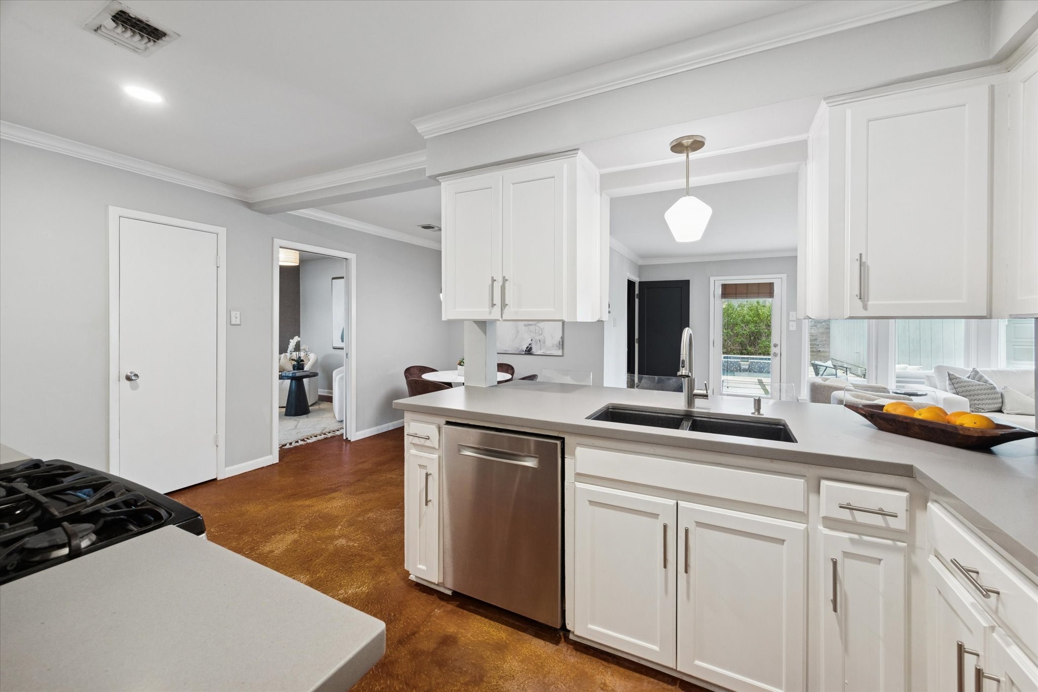 5234 Libbey Drive Houston, TX 77092 - Photo 19 of 35 The kitchen features sleek quartz countertops and a granite double sink, offering a seamless view into the bright breakfast area and open living room.