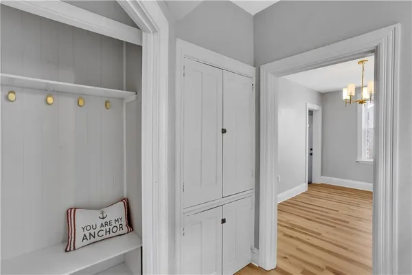 a view of a hallway with wooden floor and closet