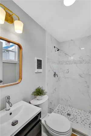 a bathroom with a sink a toilet and shower