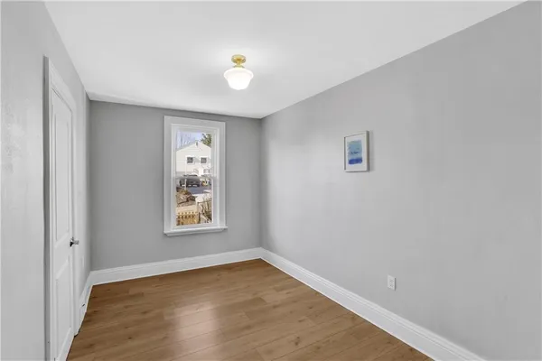 an empty room with wooden floor and window