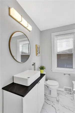 a bathroom with a toilet a sink and a mirror