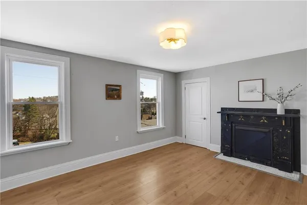 a view of empty room with wooden floor and window