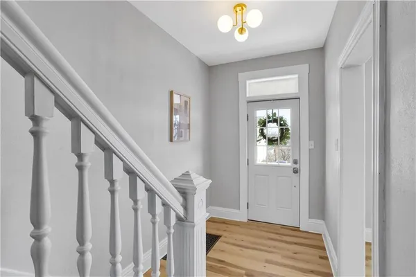 a view of a hallway with wooden floor and staircase