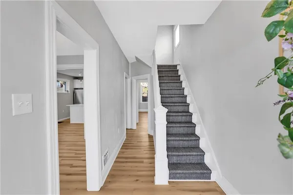 a view of a hallway with wooden floor and stairs