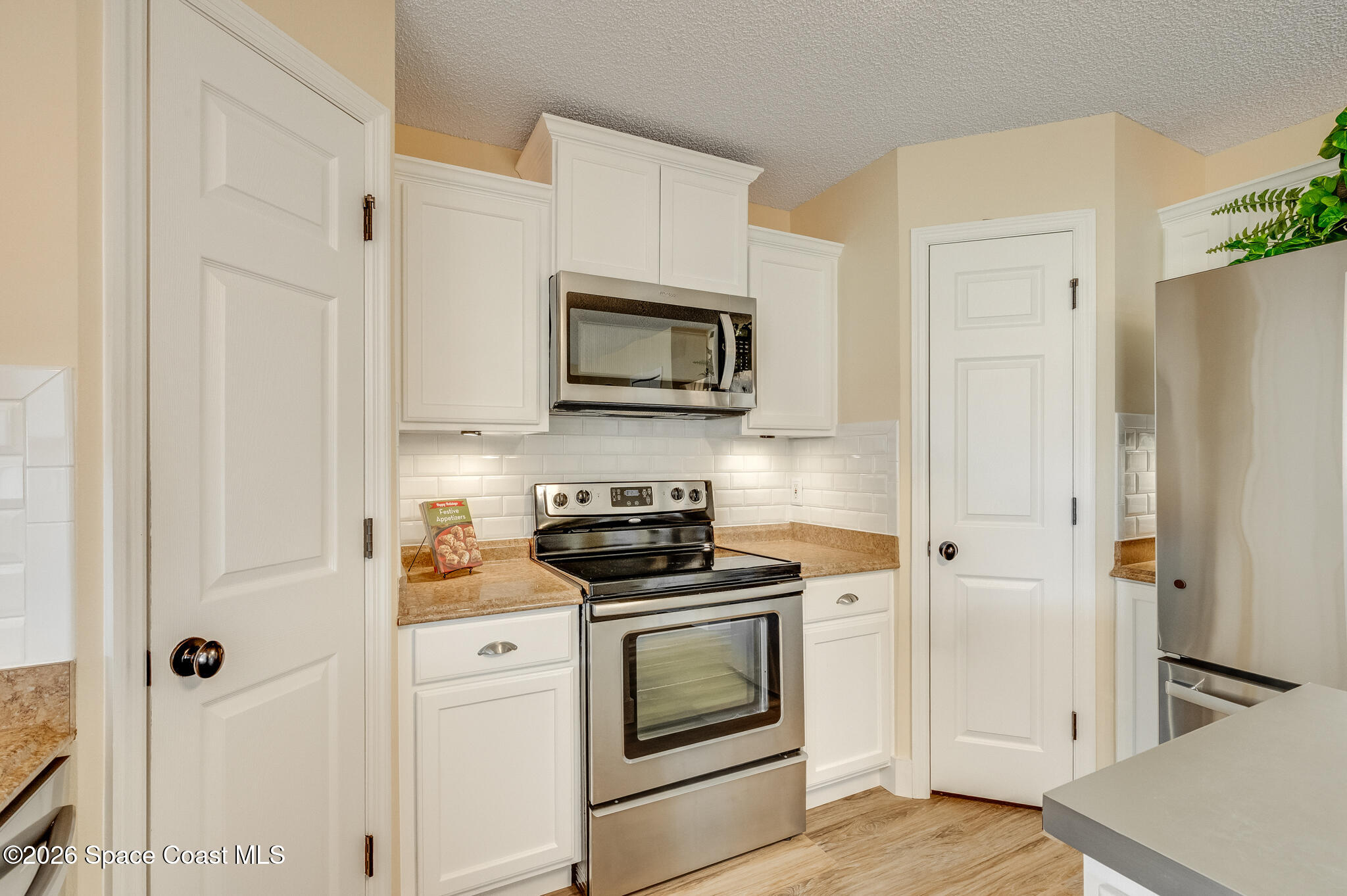 2250 Spring Creek Circle Palm Bay, FL 32905 - Photo 14 of 84 a kitchen with stainless steel appliances white cabinets and a stove top oven