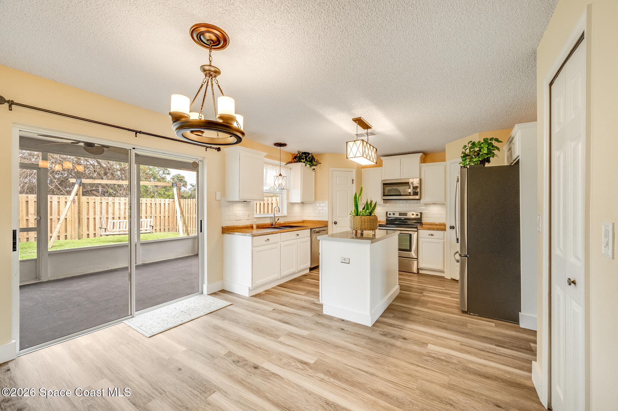 2250 Spring Creek Circle Palm Bay, FL 32905 - Photo 16 of 84 a large kitchen with cabinets and wooden floor