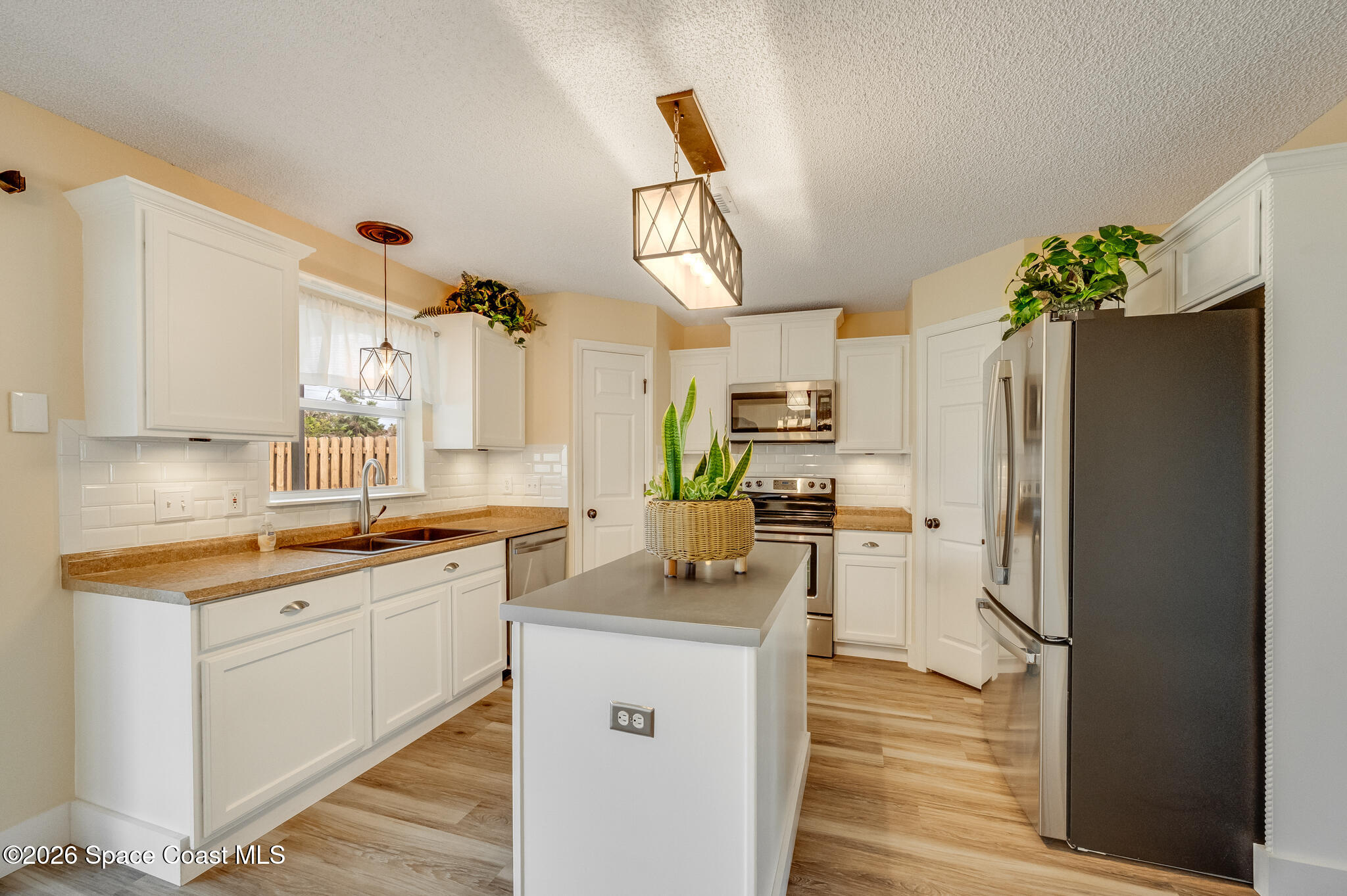 2250 Spring Creek Circle Palm Bay, FL 32905 - Photo 19 of 84 a kitchen with a sink refrigerator and cabinets
