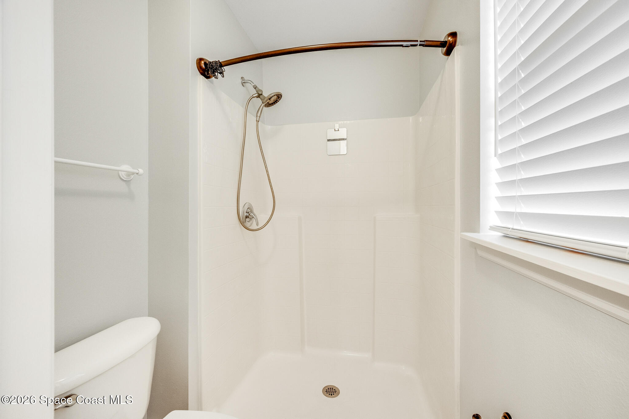 2250 Spring Creek Circle Palm Bay, FL 32905 - Photo 42 of 84 a bathroom with a shower and a shower curtain