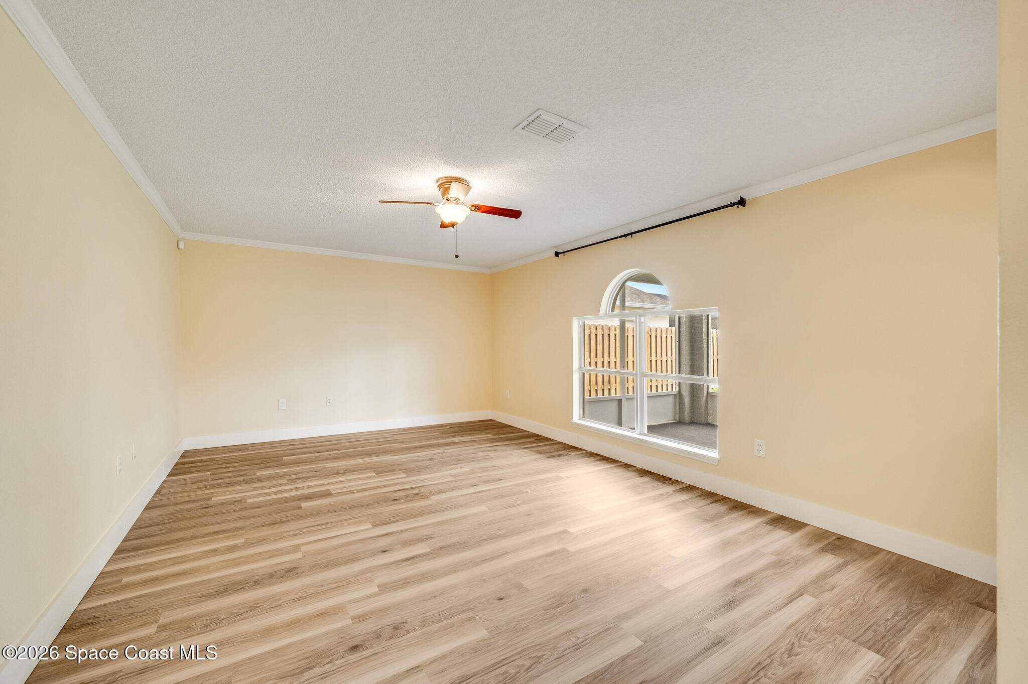 2250 Spring Creek Circle Palm Bay, FL 32905 - Photo 57 of 84 an empty room with wooden floor chandelier fan and windows