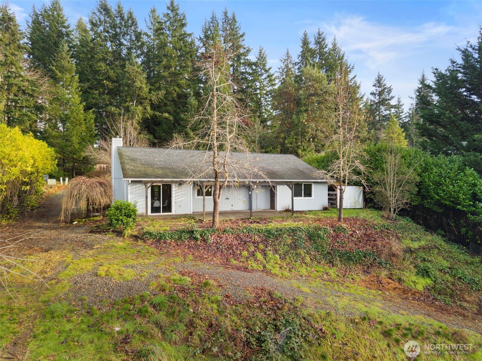 421 Northeast Cutlass Way Belfair, WA 98528 - Photo 22 of 35 a house that has a tree in front of it