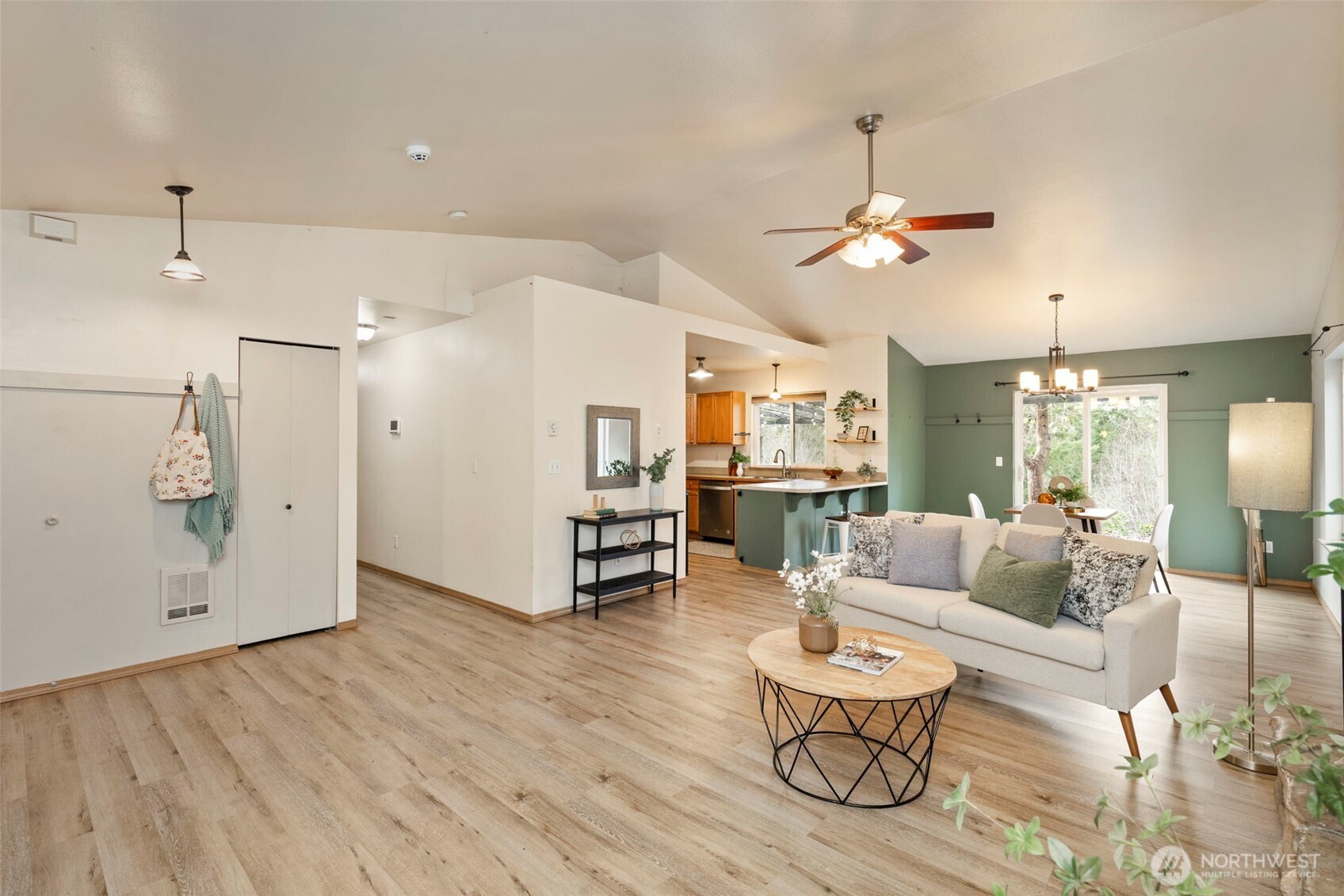 421 Northeast Cutlass Way Belfair, WA 98528 - Photo 9 of 35 a living room with couches and kitchen view with wooden floor
