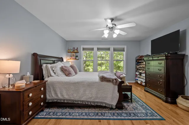 a bedroom with a bed and a flat tv screen on dresser