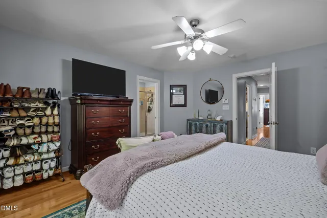 a bedroom with a bed and a flat tv screen on dresser