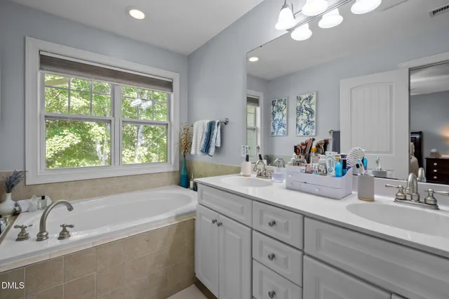 a bathroom with a tub a sink and large window