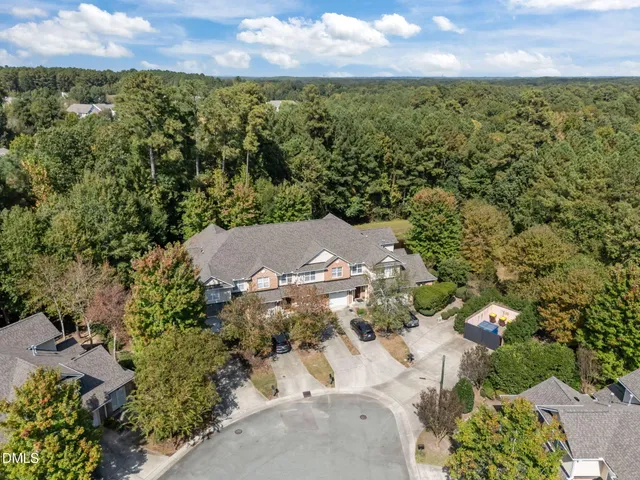 an aerial view of residential houses with outdoor space and trees