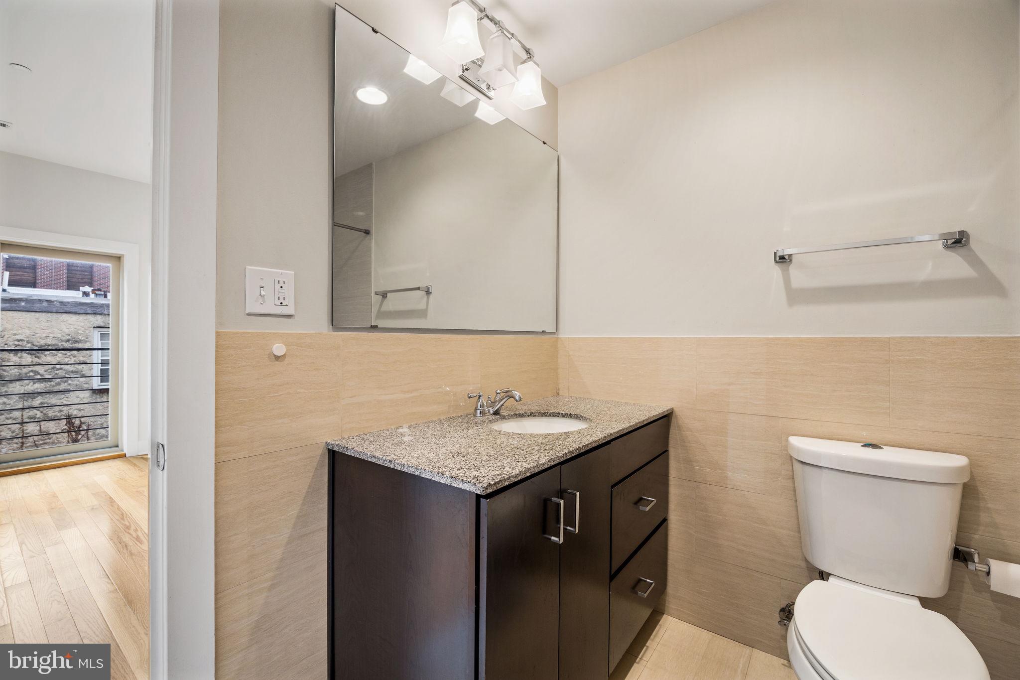2140 Carpenter Street Philadelphia, PA 19146 - Photo 20 of 41 a bathroom with a granite countertop toilet sink and mirror