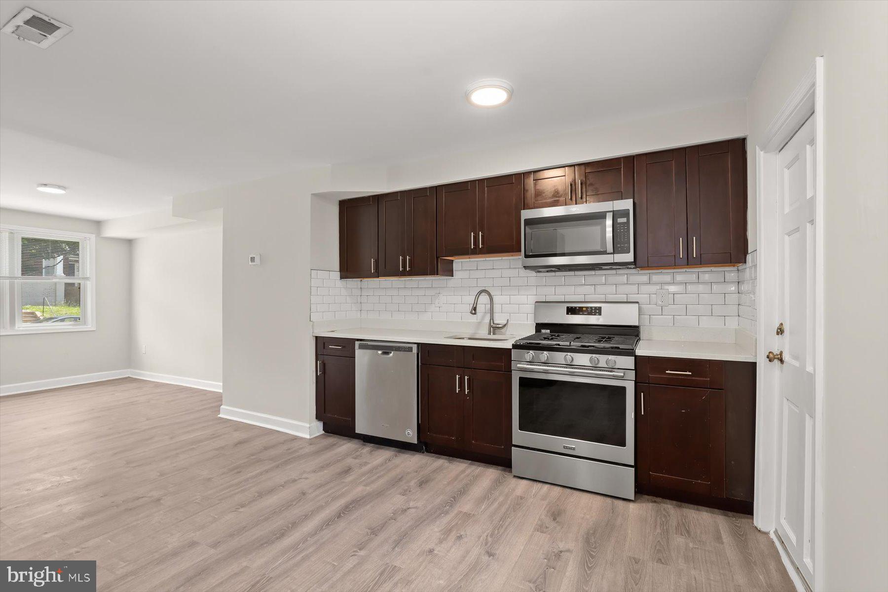 1044 Ellicott Driveway Baltimore, MD 21216 - Photo 7 of 26 a kitchen with a stove and a microwave
