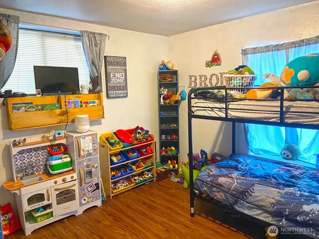 a bedroom with a bed and wooden floor