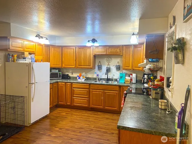a kitchen with stainless steel appliances granite countertop a refrigerator a stove and a sink