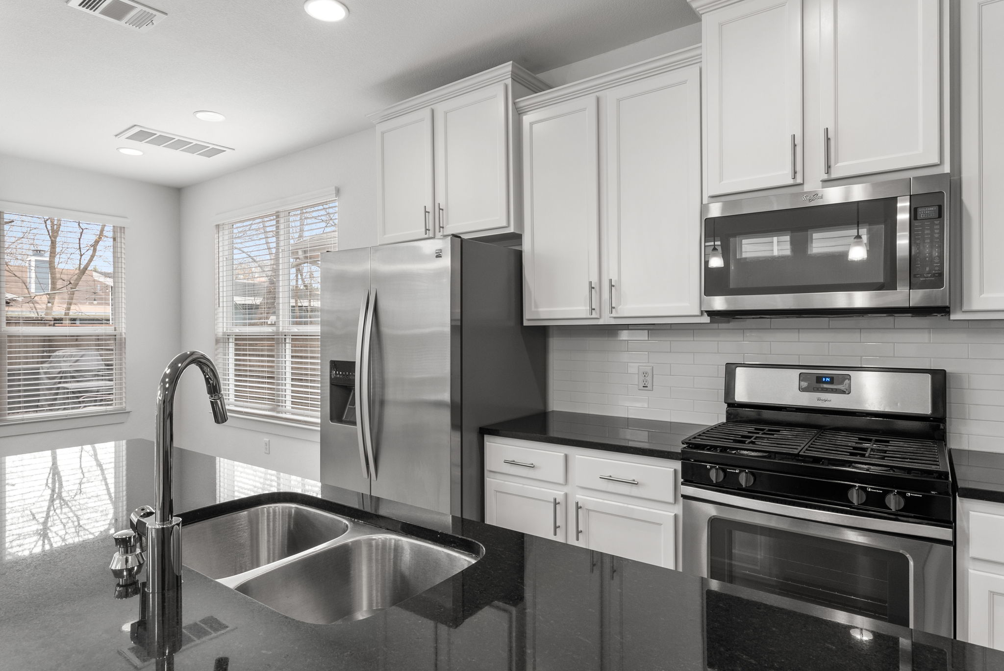 1501 Homespun Road Austin, TX 78745 - Photo 15 of 33 Kitchen with stainless steel appliances, dark stone countertops, white cabinets, recessed lighting, and decorative backsplash