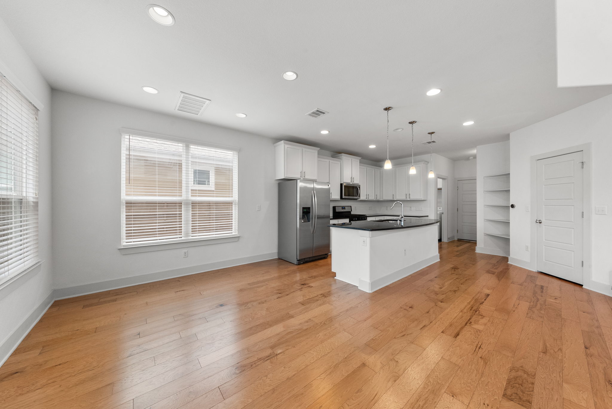 1501 Homespun Road Austin, TX 78745 - Photo 33 of 33 Kitchen featuring dark countertops, stainless steel appliances, open floor plan, and light wood-style flooring