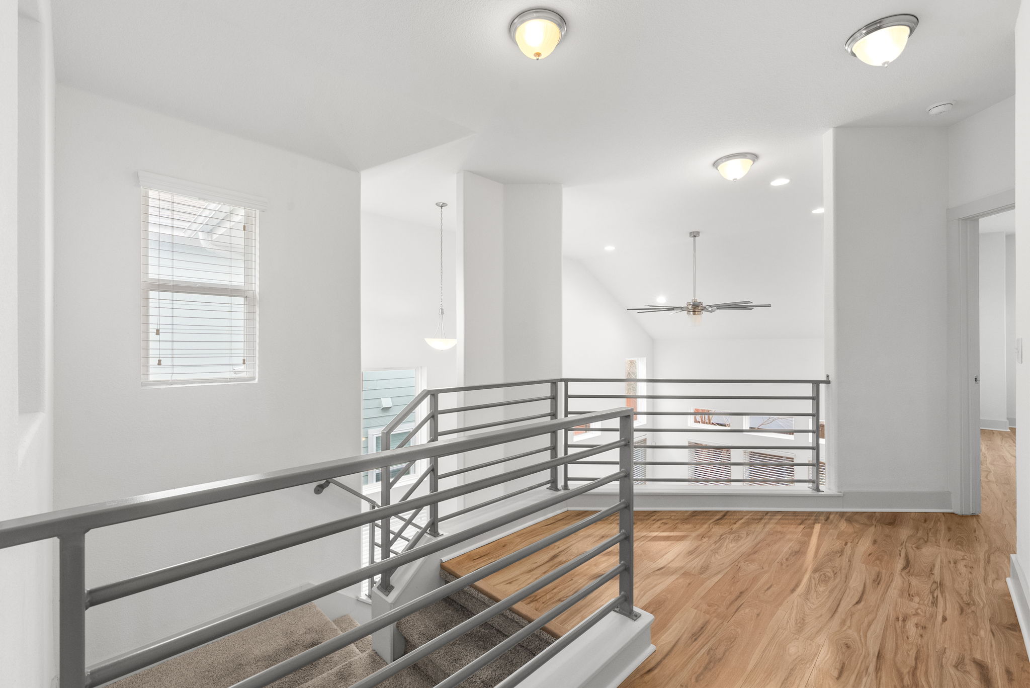 1501 Homespun Road Austin, TX 78745 - Photo 28 of 33 Hallway featuring an upstairs landing, light wood-style flooring, and lofted ceiling