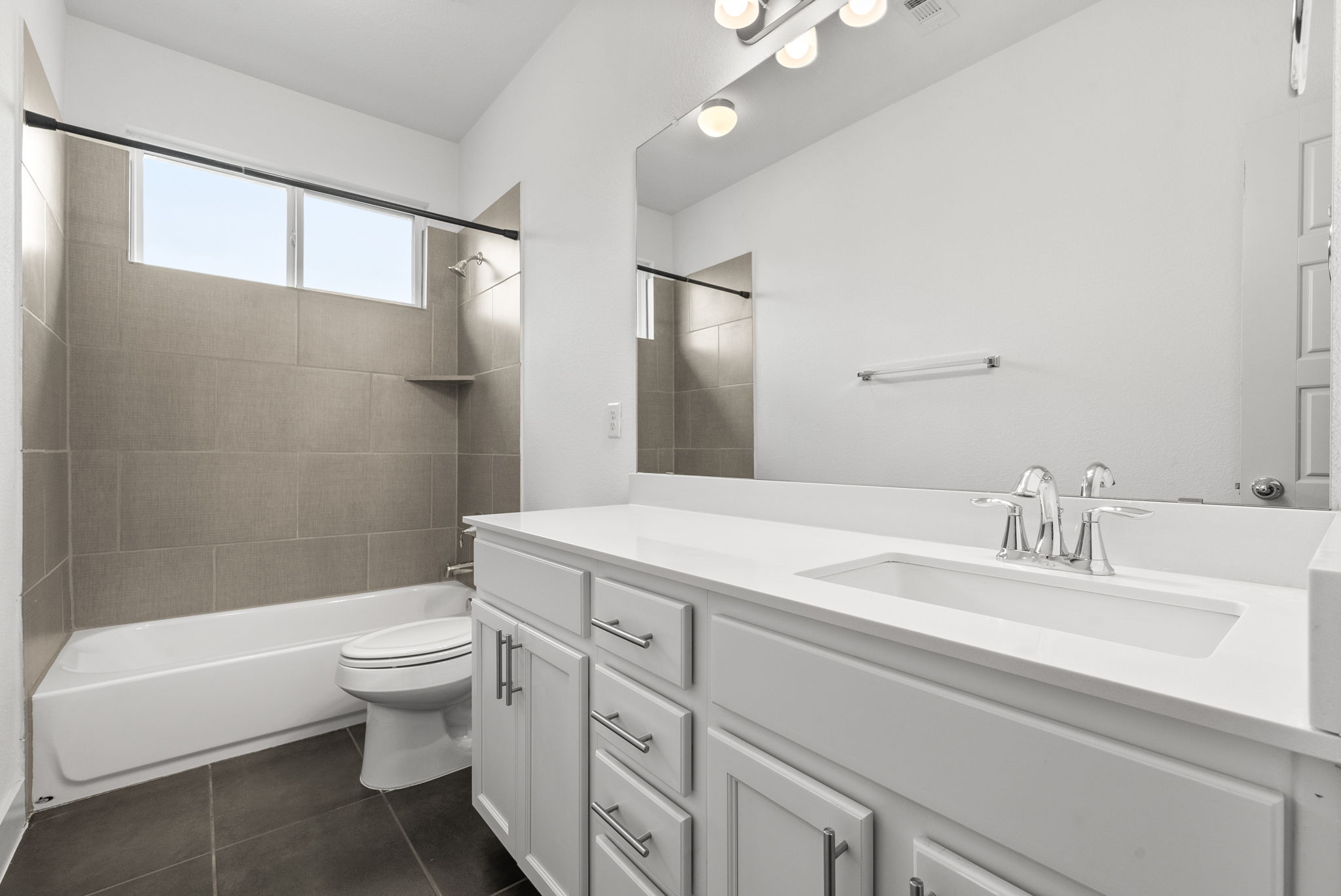 1501 Homespun Road Austin, TX 78745 - Photo 29 of 33 Bathroom with vanity, bathing tub / shower combination, and dark tile patterned floors