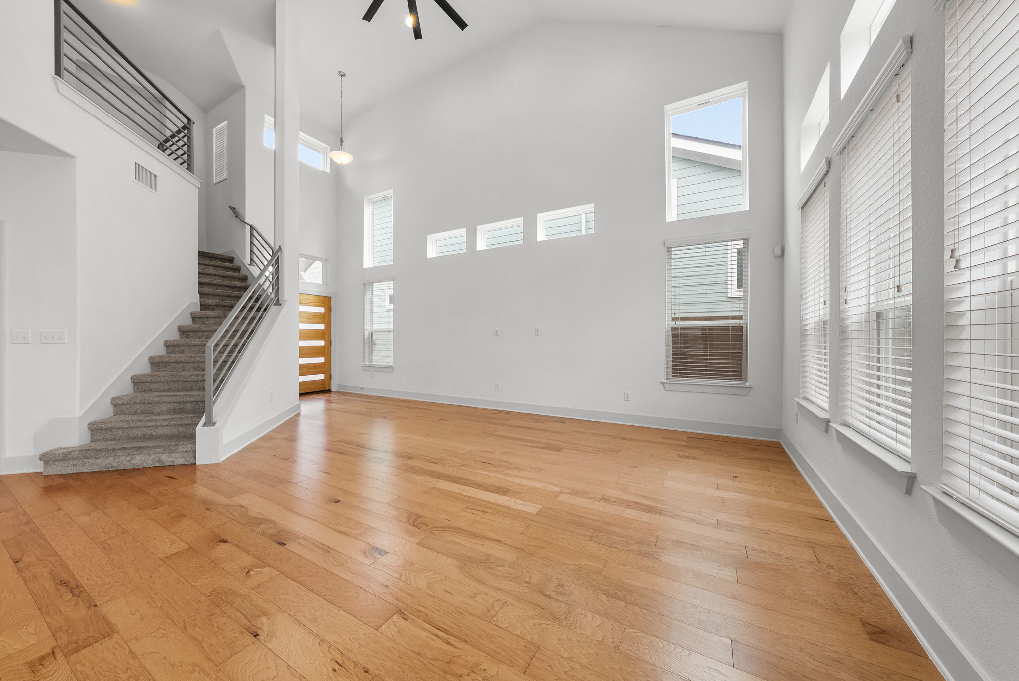 1501 Homespun Road Austin, TX 78745 - Photo 3 of 33 Unfurnished living room featuring light wood-type flooring, a high ceiling, and a ceiling fan