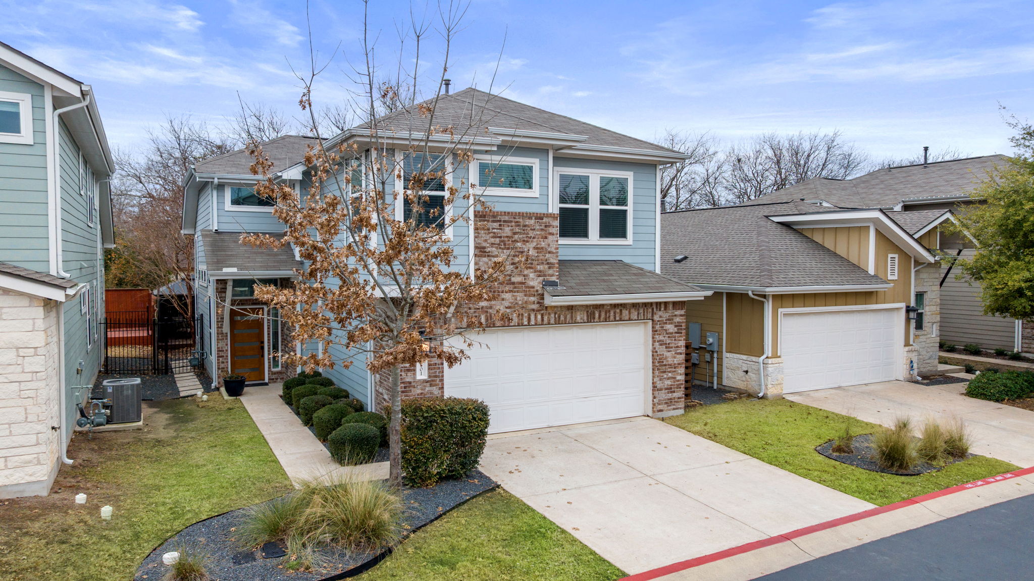 1501 Homespun Road Austin, TX 78745 - Photo 8 of 33 Traditional home featuring roof with shingles, driveway, brick siding, a garage, and a front yard