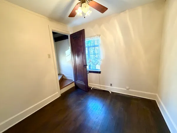 an empty room with wooden floor and window