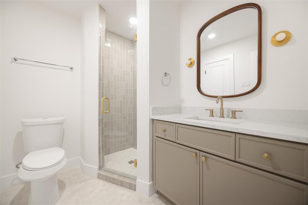 16805 Deer Park Drive Dallas, TX 75248 - Photo 32 of 39 a bathroom with a toilet a sink a mirror and vanity