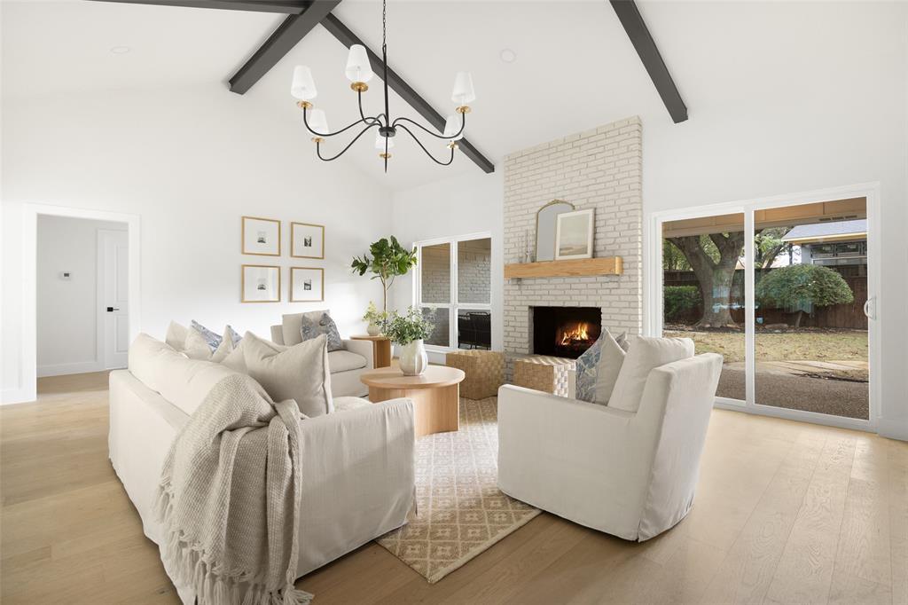16805 Deer Park Drive Dallas, TX 75248 - Photo 7 of 39 a living room with furniture a fireplace and a chandelier