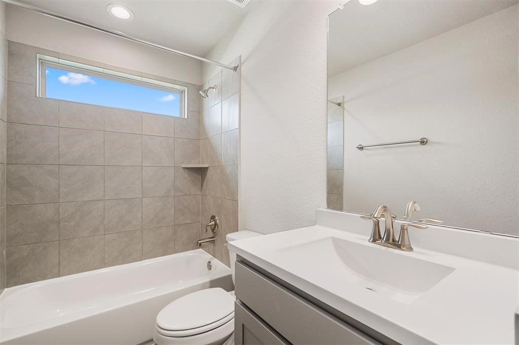 2103 Spring Hollow Drive Baytown, TX 77521 - Photo 19 of 27 a bathroom with a sink a toilet and a bathtub