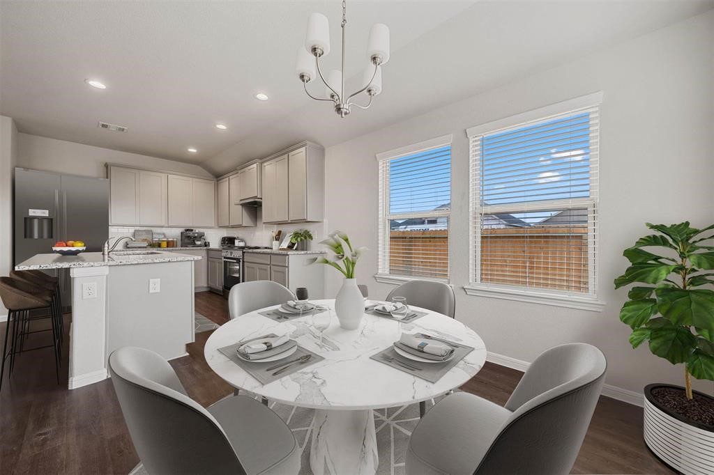 2103 Spring Hollow Drive Baytown, TX 77521 - Photo 8 of 27 a kitchen with a dining table chairs and white appliances