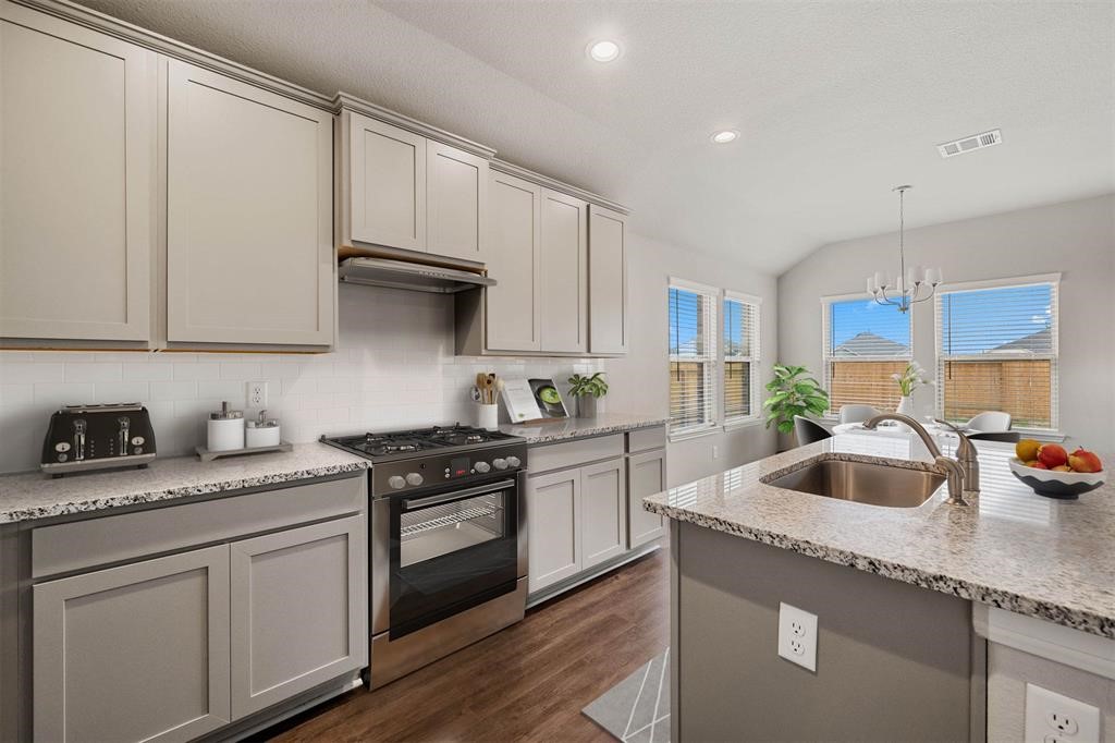 2103 Spring Hollow Drive Baytown, TX 77521 - Photo 9 of 27 a kitchen with granite countertop a sink a stove and cabinets