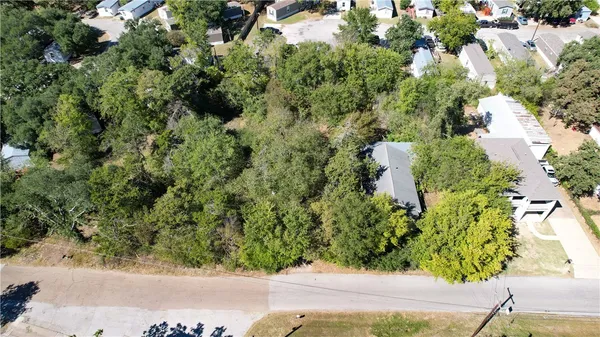 an aerial view of residential houses with outdoor space and trees all around