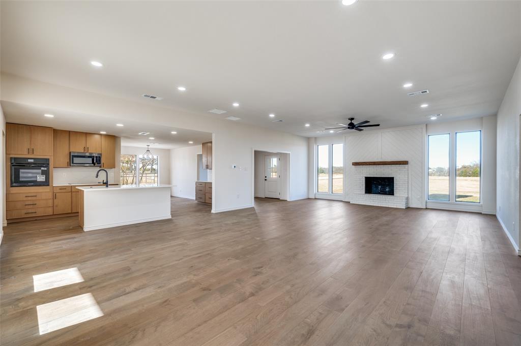 10422 Strittmatter Road Pilot Point, TX 76258 - Photo 2 of 30 a view of an empty room with kitchen and fireplace