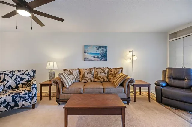 a living room with furniture and a ceiling fan