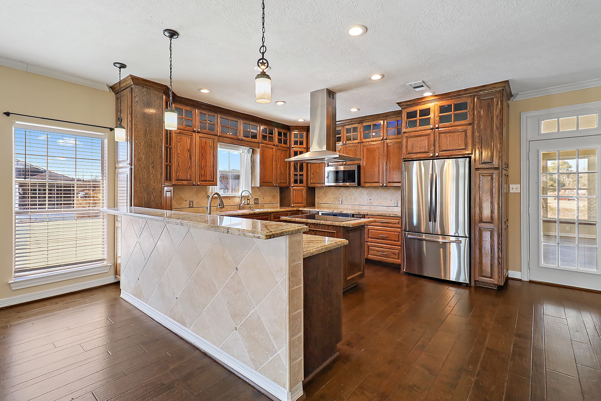 1306 Spring Branch Drive Baytown, TX 77523 - Photo 28 of 38 a kitchen with stainless steel appliances granite countertop a refrigerator a stove and a wooden floors