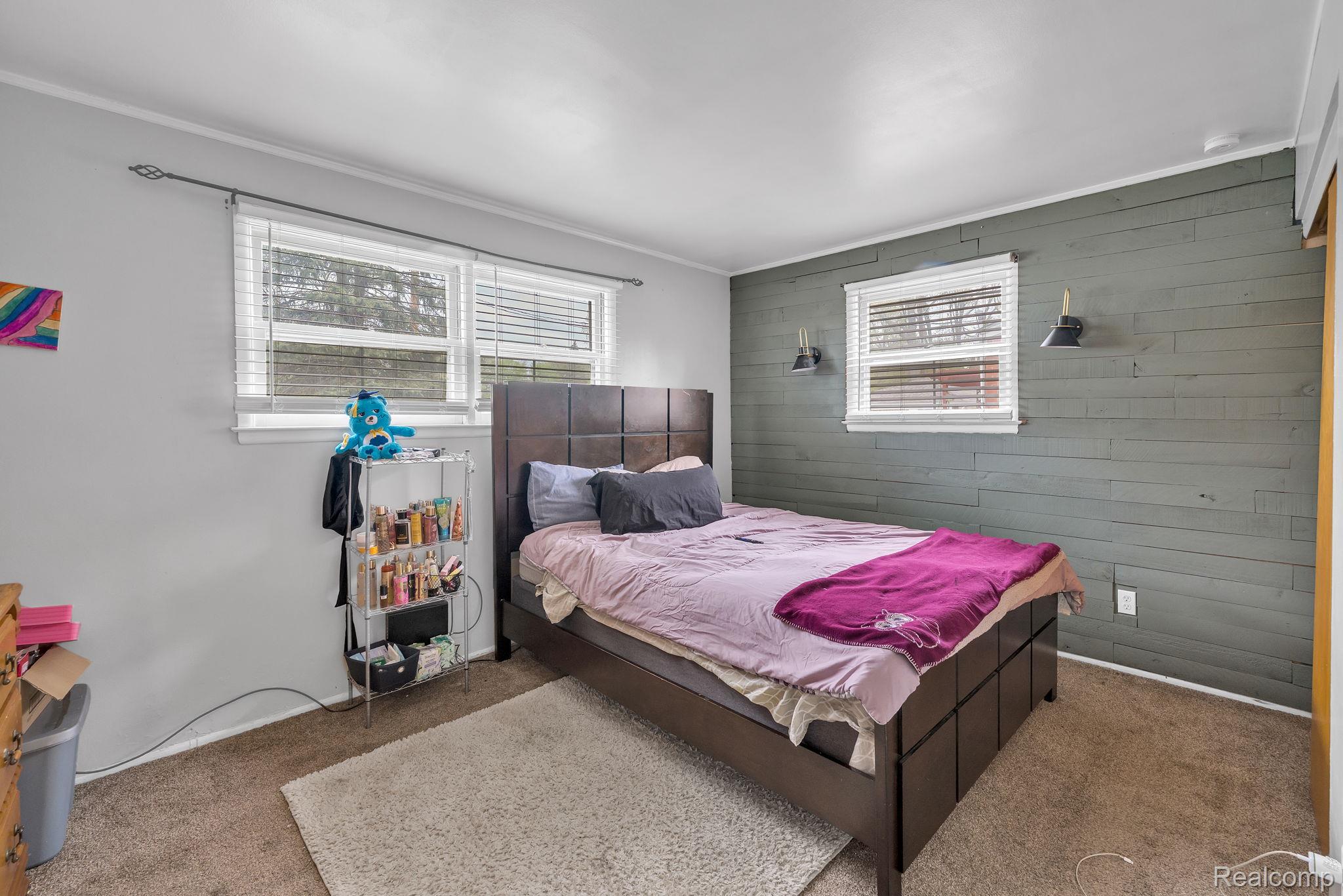 37022 Pinewood Road Wayne, MI 48184 - Photo 7 of 30 Carpeted bedroom with wood walls, crown molding, and an accent wall