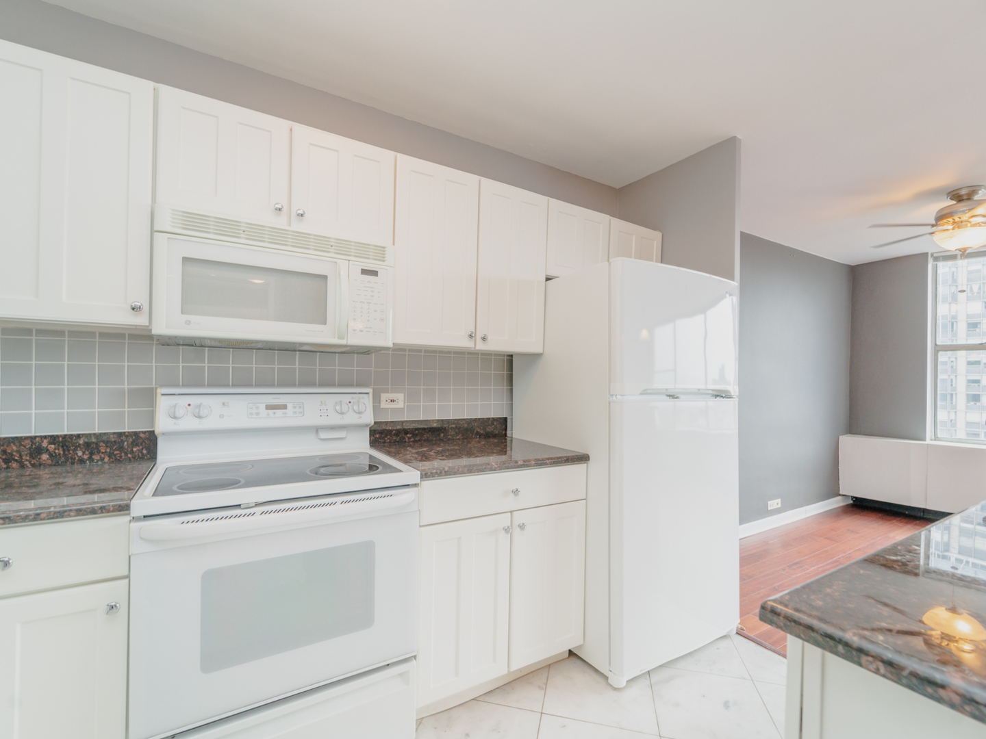 5757 North Sheridan Road, Unit 20F Chicago, IL 60660 - Photo 10 of 35 a kitchen with granite countertop white cabinets and white appliances