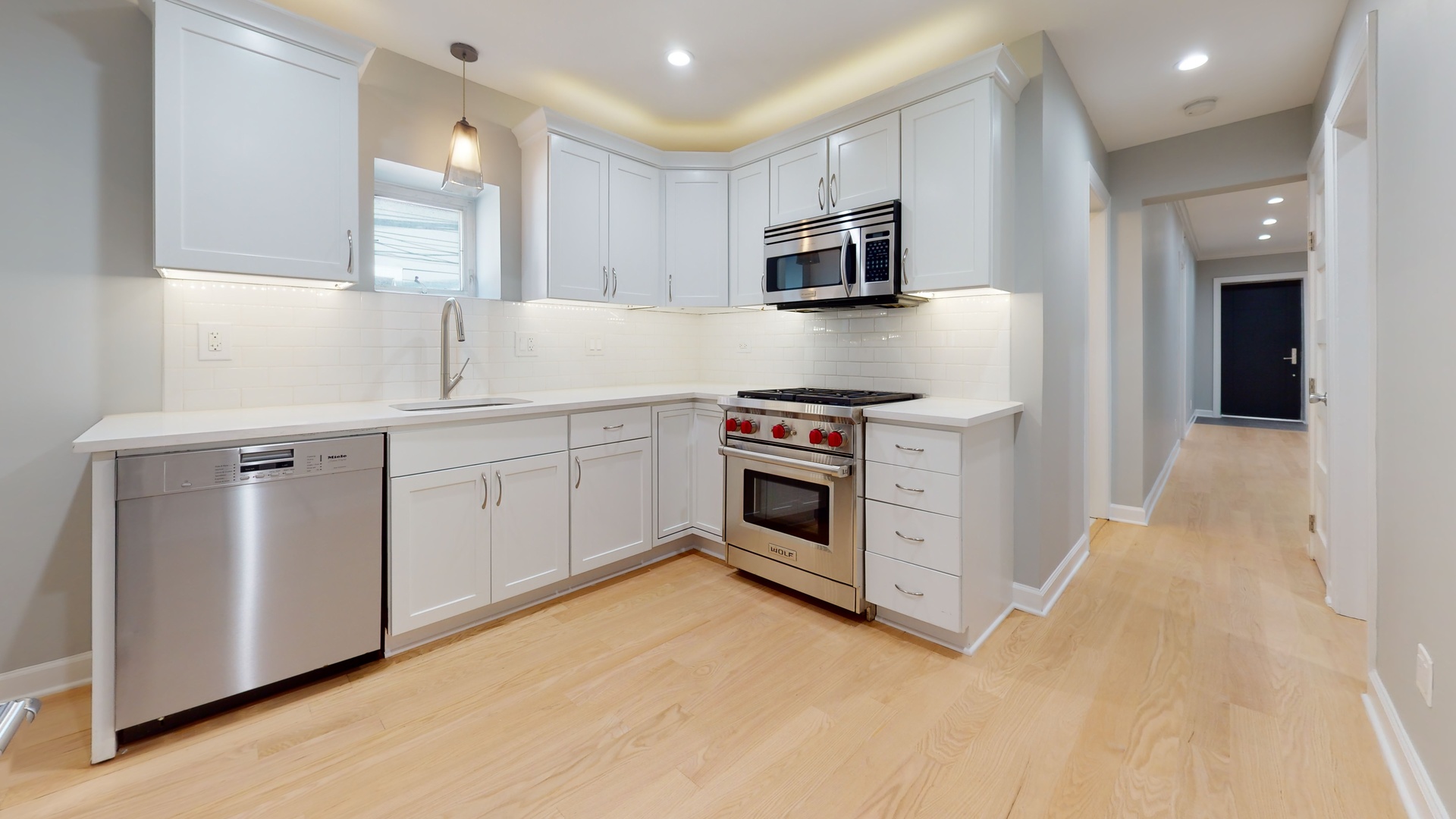 1543 West George Street, Unit 1 Chicago, IL 60657 - Photo 7 of 18 a kitchen with white cabinets stainless steel appliances and sink