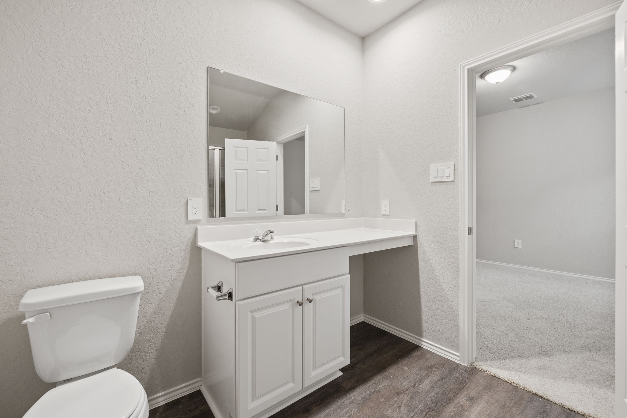 3209 Ridge Place Seguin, TX 78155 - Photo 15 of 23 Half bathroom with a textured wall, vanity, and dark wood-style flooring