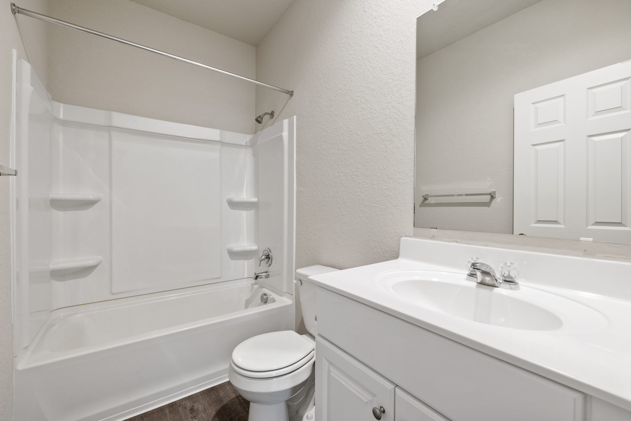3209 Ridge Place Seguin, TX 78155 - Photo 19 of 23 Bathroom with a textured wall, vanity, shower / washtub combination, and dark wood finished floors